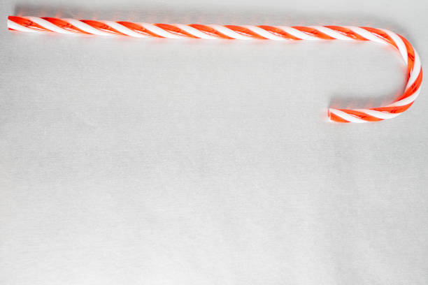 Christmas candy canes laying down on a grey background. Christmas Background.