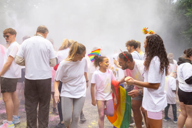 A lively family enjoys a 5K colour run, with colourful powder filling the air. A young girl smiles at her father as she's covered in colourful powder. The scene captures the fun and energy of a community event, filled with joy and celebration.\n\nVideos are available similar to this Scenario.