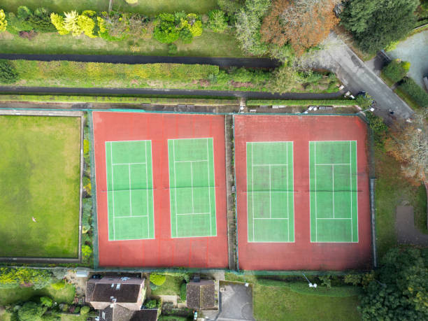 istock Four side by side public tennis courts seen in a typical British town. 2177454027