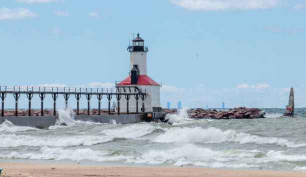 Lake Michigan waves crashing on to the Michigan City Lighthouse on a summer day with high surf warning