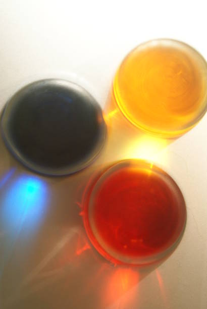 Abstract photography looking down at three glasses filled with colored water.