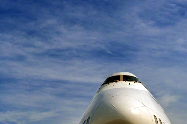 Low Angle View Of Airplane Flying Against Clear Blue Sky