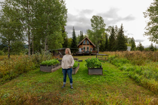 istock Woman stands in front of leafy vegetable garden 2177457784
