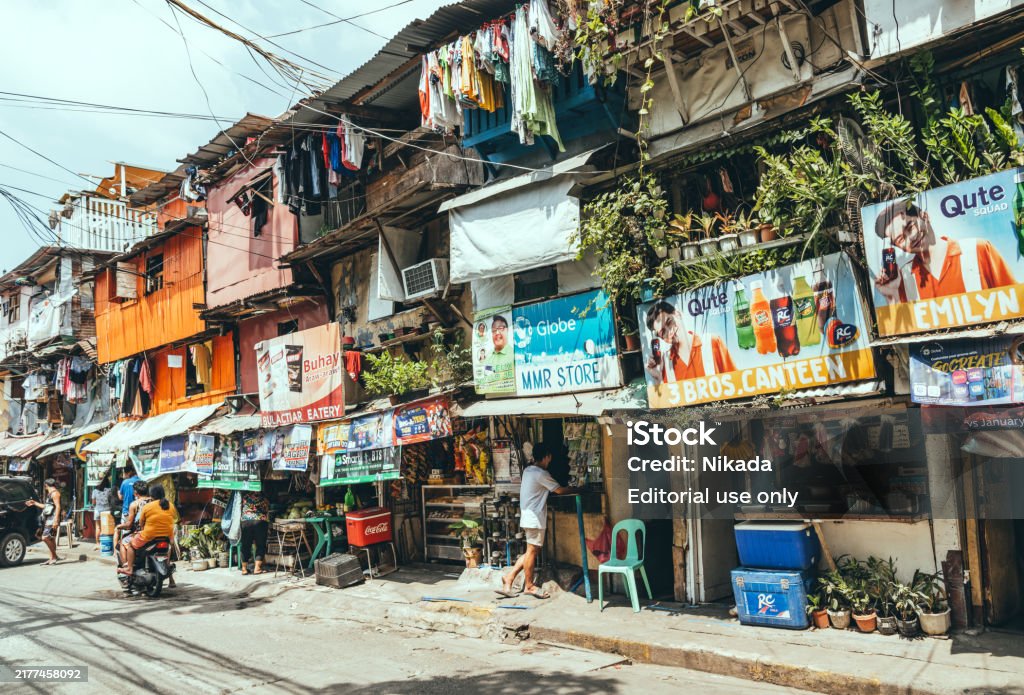 Crowded and poor area in Manila, Philippines Manila, Philippines - March 05, 2022: Slums and illegal settlements scattered across the metropolitan area in downtown near the street. People do daily work. Slum Stock Photo Crowded and poor area in Manila, Philippines Manila, Philippines - March 05, 2022: Slums and illegal settlements scattered across the metropolitan area in downtown near the street. People do daily work. Slum Stock Photo