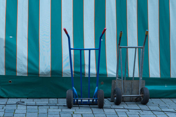Shot of unrecognizable delivery guy pushing cart full of parcels.