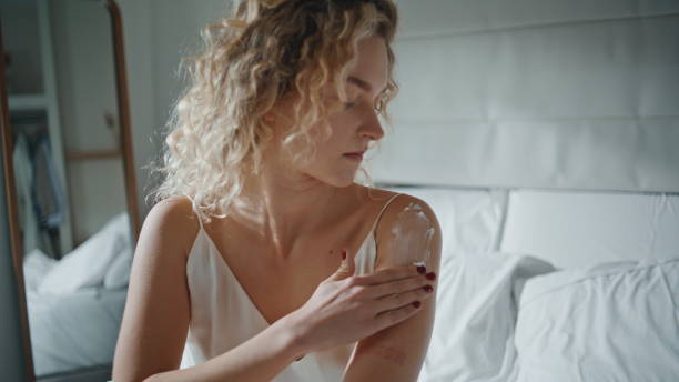 istock Woman using moisturizing cream in morning sunlight. Closeup hands rubbing lotion 2177459168