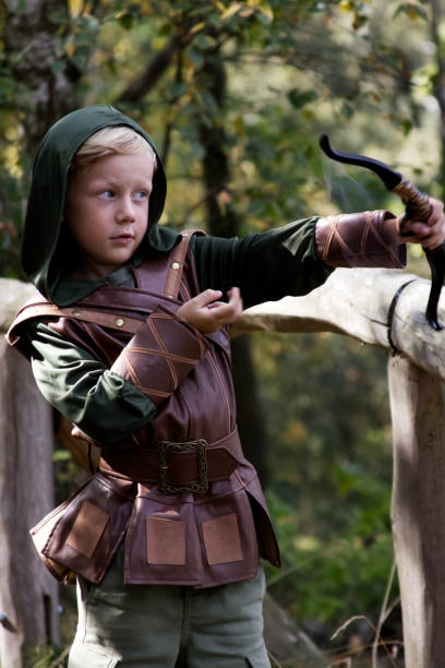 istock Portrait of a boy in a medieval costume holding a bowstring against a forest background 2177459687