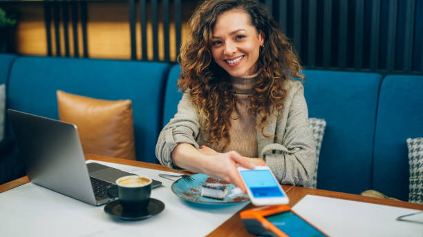 Woman in restaurant using digital wallet for mobile payment