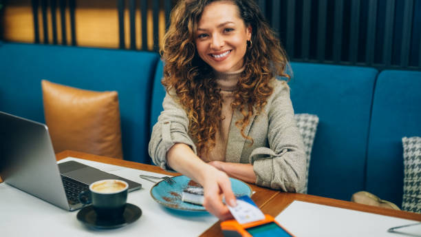 istock Woman in restaurant using contactless credit card 2177462851