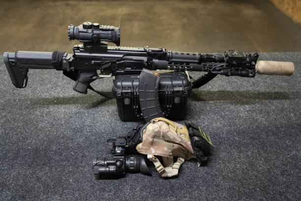 istock Tactical rifle shooting at indoors shooting range, AK series rifle with a silencer, laser sight, flashlight and night vision device. 2177463040