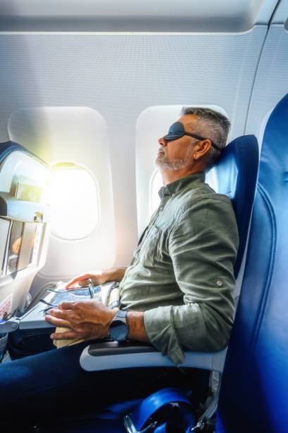 istock Mature man sleeping with a mask in an airplane. 2177467104