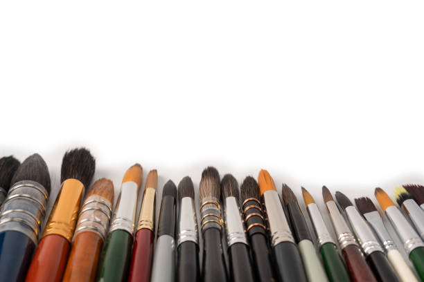 A collection of used paintbrushes in a jar, photographed in soft natural light with shallow depth of field. The image conveys a sense of creativity, artistic atmosphere, and daily life inside a working artist’s studio. Ideal for themes of inspiration, craftsmanship, and visual storytelling.