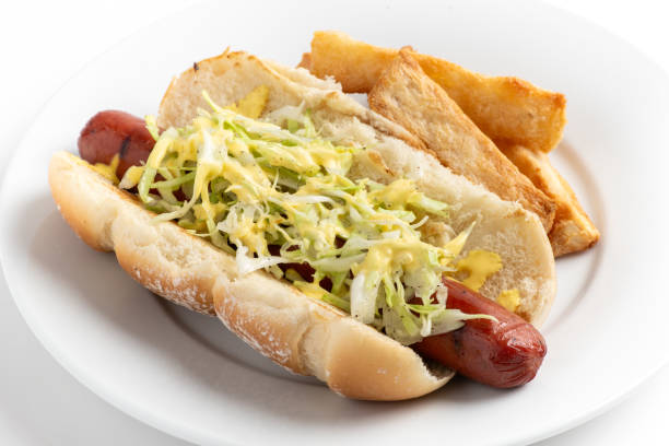 Hot dog with ketchup on a white plate. Close up.