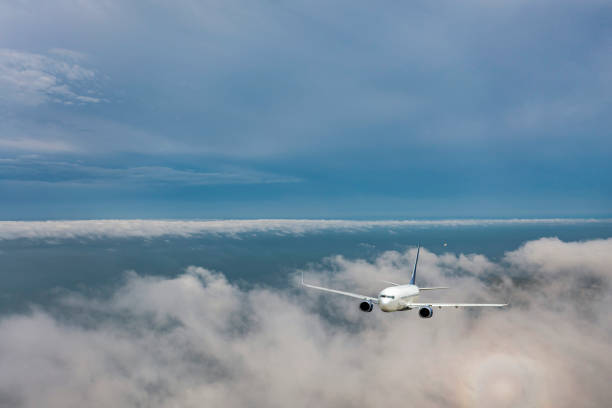 Passenger Jet airplane flying over clouds.