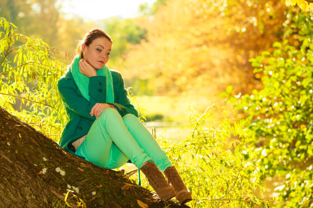Young woman enjoying perfect autumn day on hiking in nature. She wears nice yellow sweater and she is beautiful and cute.