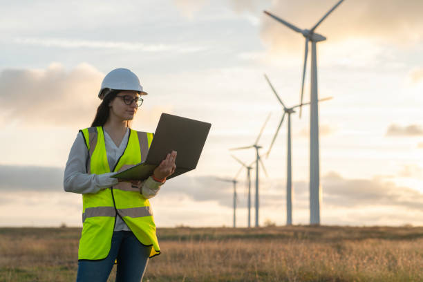 istock Caucasian female technician working outdoors in the wind turbines field with laptop. 2177489331