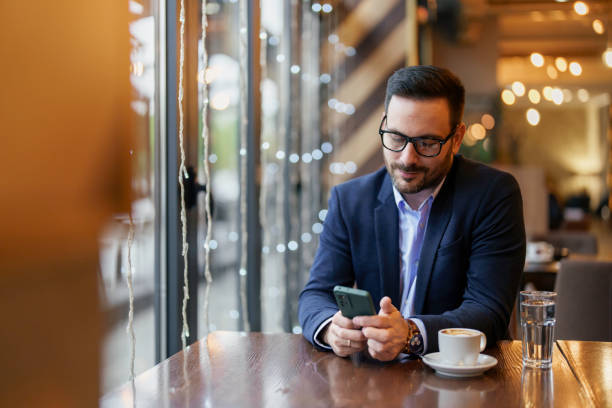 istock Businessman Engaged with Smartphone in Cafe Setting 2177490066