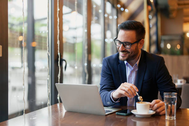 istock Smiling Businessman Engaging with Laptop in Cafe 2177490122