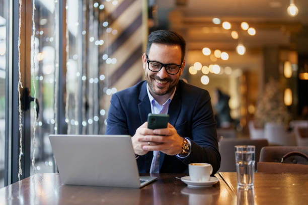 istock Mid Adult Businessman Multitasking in Cafe 2177490640