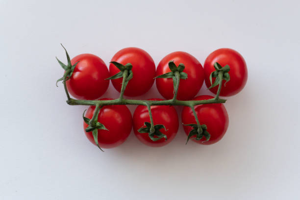 istock A branch of ripe small cherry tomatoes, isolated on a white background. 2177492398