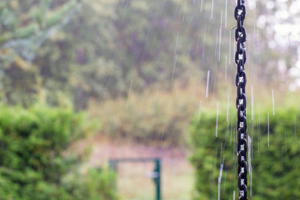 Rain chain with raindrops on autumn patio background, fall season, weather forecast concept