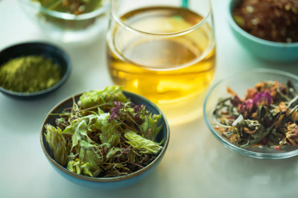 Herbal tea. Top view of a tea cup with a variety of dried tea leaves for preparing healthy detox infusions,  herbal tincture and naturopathic medicine shot on white table.