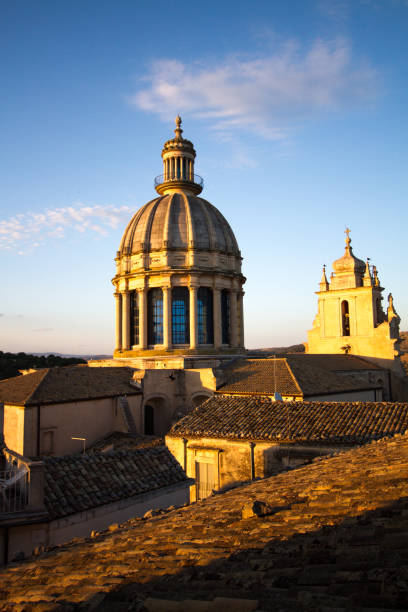 Ragusa Ibla, Sicily: The baroque 17th-century San Giorgio Cathedral at midday, with terra-cotta rooftops in the foreground. Ragusa Ibla is a UNESCO World Heritage Site.