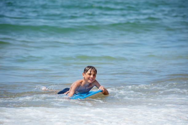 istock A youngster plays on boogie board at the seaside wait for wave 2177509017