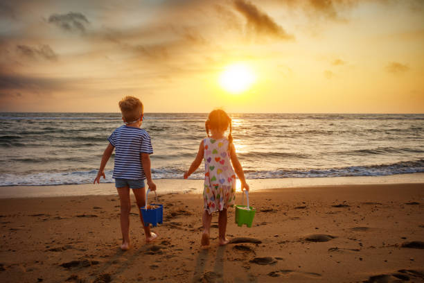 Little girl playing with water and sand at the beach