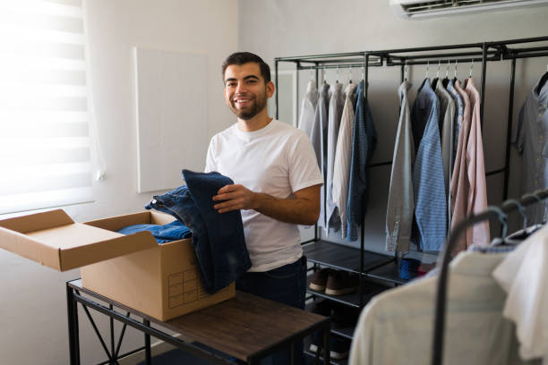 istock Latin man joyfully sorting and packing clothes in a walk-in closet during spring cleaning 2177509913