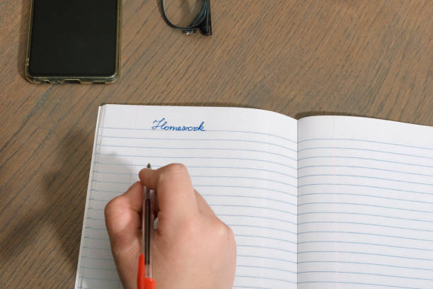istock Homework. Schoolboy teenager gets distracted by phone during class 2177510142
