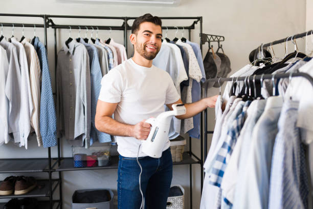 istock Young man happily steaming his shirt in a spacious closet before heading out 2177510608