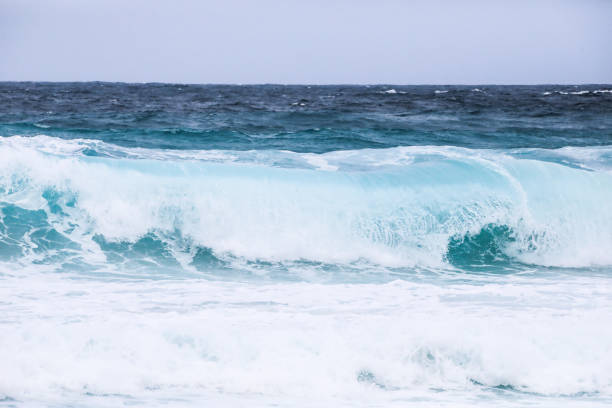 Waves on the beach in windy day. Santorini island, Greece. Blue sea and the blue sky.