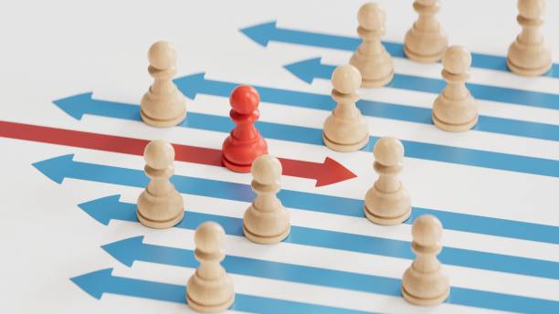 istock 3d illustration of many white pawns going on the same direction and a RED one going on the opposite side.3D rendering on white background. 2177515297