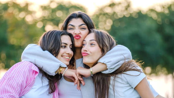istock Three beautiful young  women posing for the camera on a sunny day in a tree-filled park 2177515559