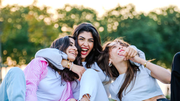 istock Three beautiful young  women posing for the camera on a sunny day in a tree-filled park 2177515589