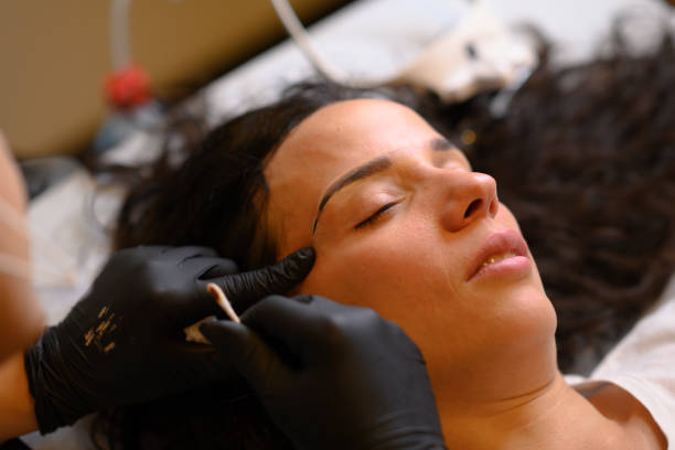 istock Beautician applying permanent eyebrow makeup with microblading machine on brunette hispanic 30 woman 2177517462