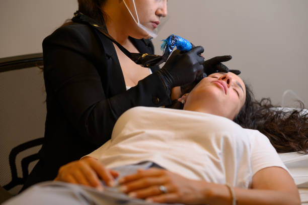 istock Beautician applying permanent eyebrow makeup on woman lying down 2177517471