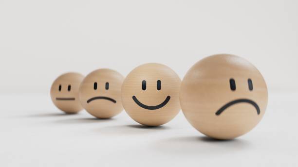 istock Small balls showing different types of emotions.Wood cube with smile, normal and sad face. Facial expressions. Mental health assessment.3D rendering on black background. 2177519024