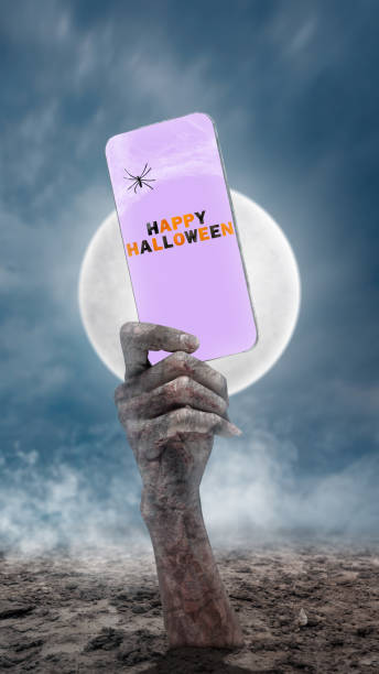 istock Mummy hands have dirty bandages on them. Mummy, devil, evil, satan, or zombie hands holding a mobile phone with a Happy Halloween sign 2177531247