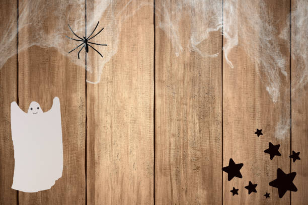 istock White ghost and spider on spider cobweb on wooden wall background. Halloween decoration concept. Mockup. Copy Space 2177531508
