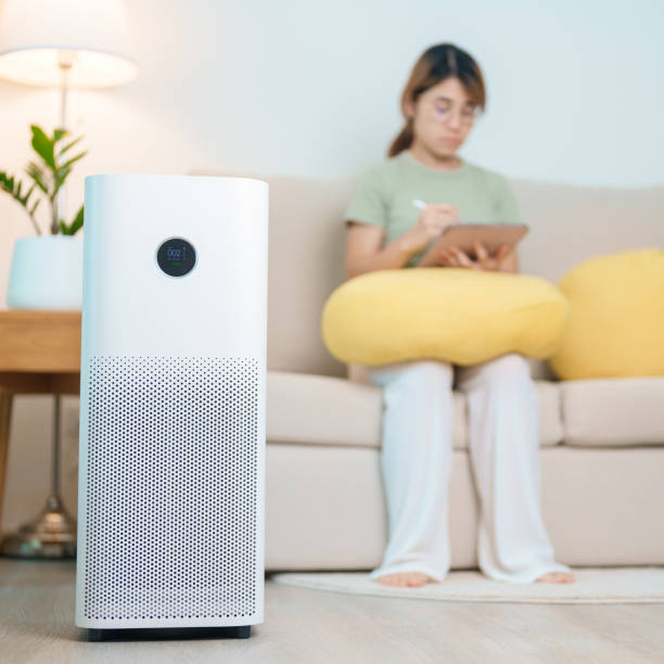 istock Air Purifier with woman relax and use tablet on sofa. Purification system for filter and cleaning dust PM2.5 HEPA and virus in home. Allergy, Pure air, health, Wellness lifestyle and Air Pollution 2177533822
