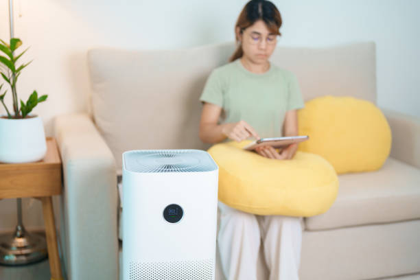 istock Air Purifier with woman relax and use tablet on sofa. Purification system for filter and cleaning dust PM2.5 HEPA and virus in home. Allergy, Pure air, health, Wellness lifestyle and Air Pollution 2177533844