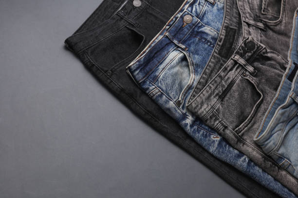 istock Many jeans pants on gray background. Top view. Coy space 2177536006