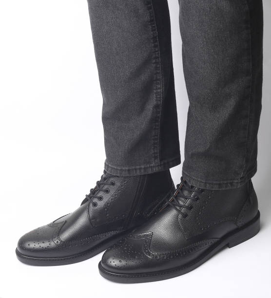 istock Male legs in black leather brogue boots on a white background 2177536141