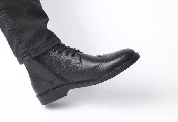 istock Male leg in black leather brogue boot on a white background 2177536143