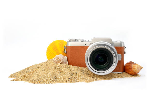 Mature man wearing a straw hat, photographing product with a long lens and a DSLR camera.
