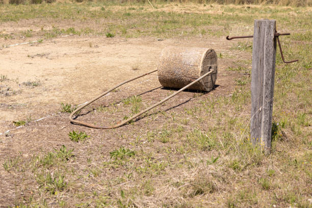 An old style concrete roller and net post on an abandoned granite gravel base tennis court in New South Wales, Australia