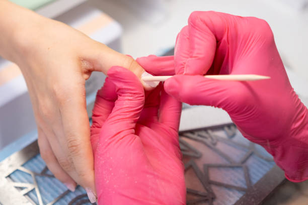 istock Close up manicure master uses an orange stick to remove cuticula pro clients fingers 2177538919