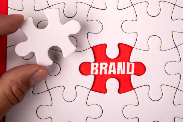 istock Brand Concept. White puzzle pieces and text on an red background 2177543384